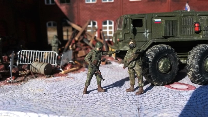 Der russische Offizier gibt seinen Soldaten den Befehl, die umliegenden Häuserruinen zu sichern.