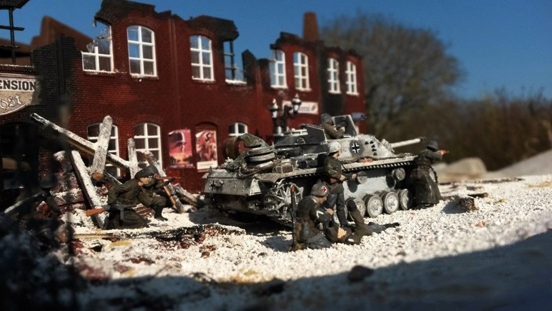 Währenddessen gibt der Panzerkommandant seinen Kameraden mit dem Maschinengewehr MG 42 Feuerschutz.