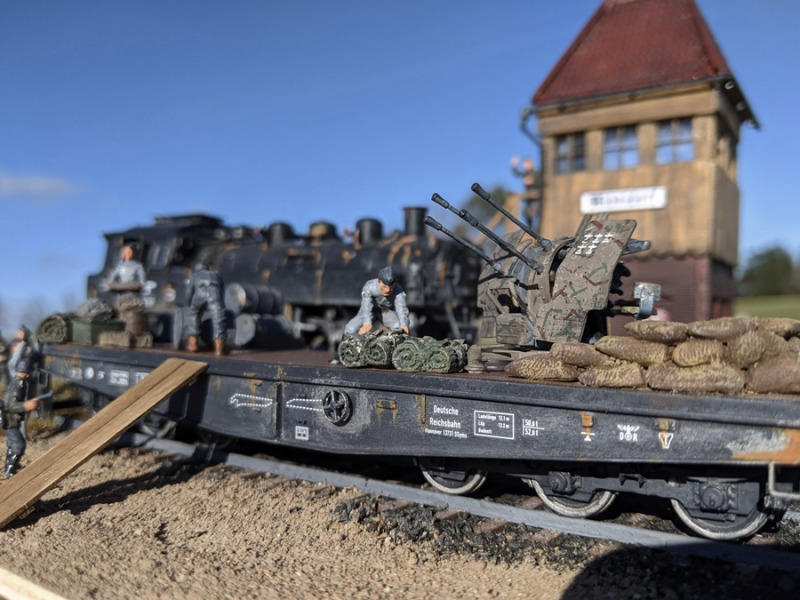 Soldaten der Wehrmacht beladen den Flachwagen der deutschen Reichsbahn mit zahlreichen Ausrüstungsgegenständen